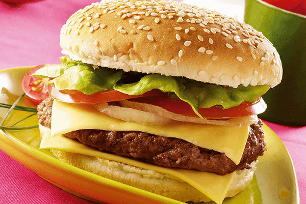 Hamburguesa con queso, lechuga y tomate en un pan con sésamo